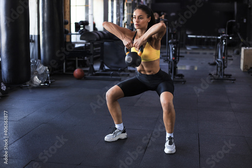 Sport woman with kettlebell in the gym.