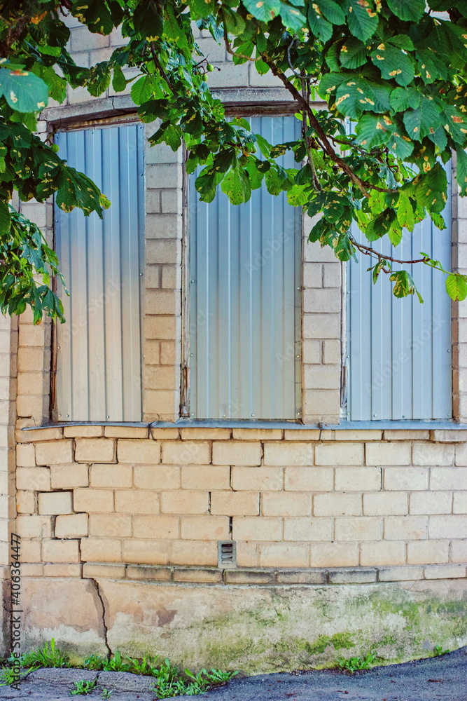 A fragment of a corner of a building with an unusual architecture and three windows A fragment of a corner of a building with an unusual architecture and three windows