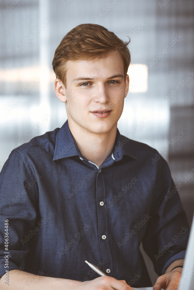 Young blond businessman working with computer. Startup business means working hard and out of time for success achievement Young blond businessman working with computer. Startup business means working hard and out of time for success achievement