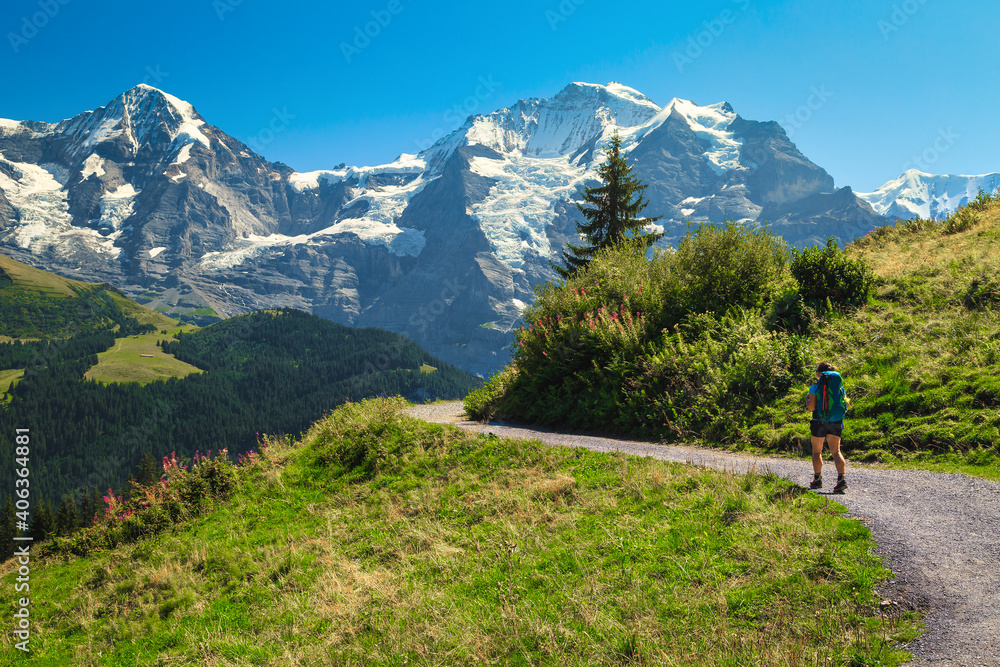 Hiker woman with backpack on the hiking trail, Murren, Switzerland