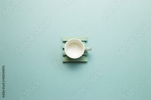 Empty mug cup on mint green background. top view, copy space