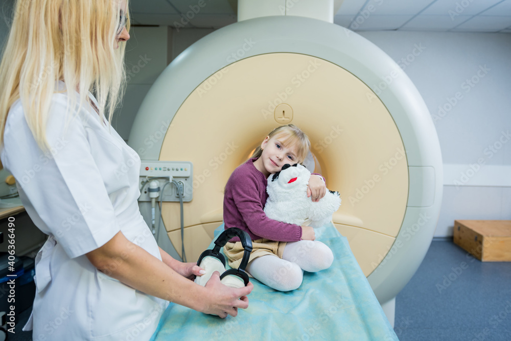 Radiologist prepares the little girl for an MRI brain examination Radiologist prepares the little girl for an MRI brain examination