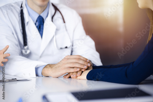 Unknown man-doctor reassuring his female patient, close-up. Two physicians consulting and giving some advices to woman. Concepts of medical ethics and trust. Empathy in medicine