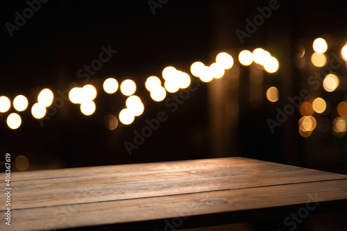 Vintage wooden table on blurred golden bokeh on a dark background. Cafe-dining-restaurant.