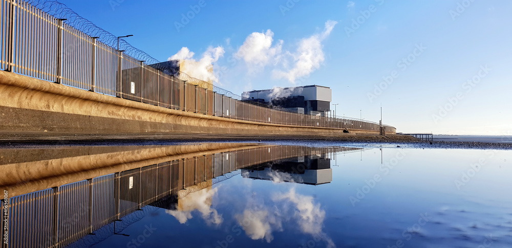 Fototapeta premium Heysham nuclear power station reflected in a puddle.