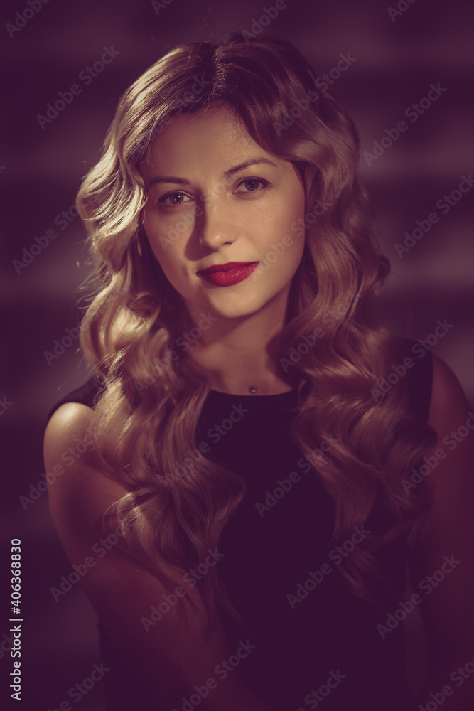 Fashion studio portrait of beautiful girl with blonde curly hair. image toned in warm colors in retro style Fashion studio portrait of beautiful girl with blonde curly hair. image toned in warm colors in retro style