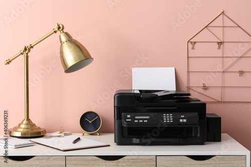 New modern printer with paper on white table at workplace photo