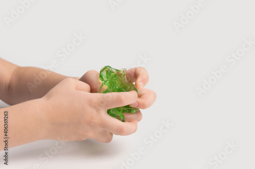 Slime in the hand of a child on a light background. The child plays with mucus and develops fine motor skills of the hands.