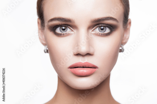 Portrait of beautiful young brunette woman with smoky eyes makeup and natural lips looking at camera. beauty, makeup health and skin care concept. indoor isolated on white background.