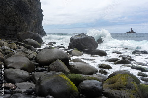 Big waves crashes into rock at stoney beach on Madeira Island