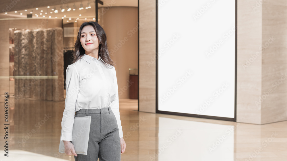 Asian business woman holding laptop in shopping mall Asian business woman holding laptop in shopping mall
