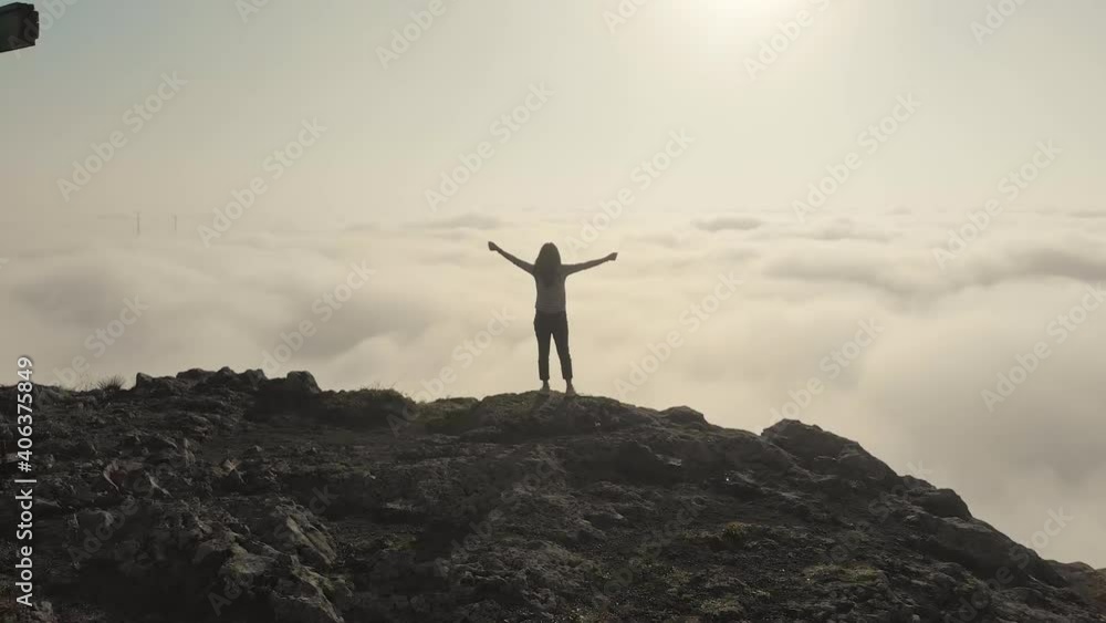 Inspirational aerial view around victorious young attractive woman with spread hands above the clouds. Daydreaming concept Inspirational aerial view around victorious young attractive woman with spread hands above the clouds. Daydreaming concept