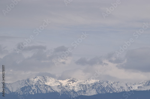 Snowy mountains meet cloudy sky  © Jeno