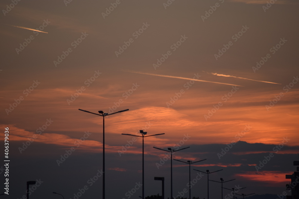 Light poles at dusk with a cloudy sky