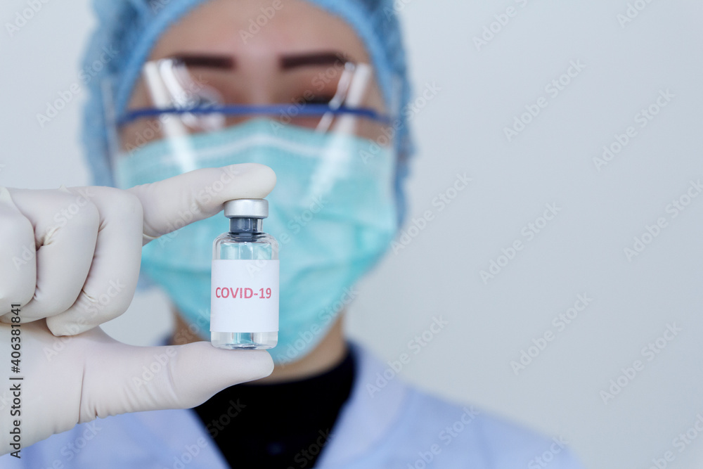 Doctor's hand holding bottle vaccine Covid-19, Medication treatment concept. Doctor's hand holding bottle vaccine Covid-19, Medication treatment concept.