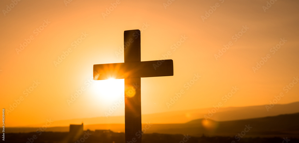 cross silhouette in nature over sunset