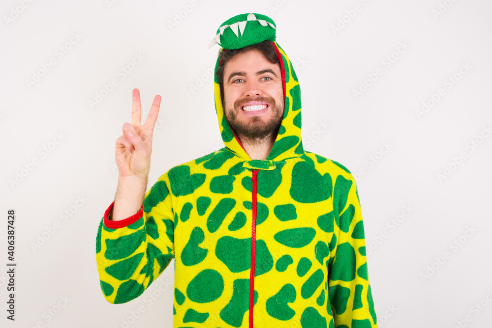 Fototapeta premium Young caucasian man wearing a pajama standing against white background showing and pointing up with fingers number two while smiling confident and happy.