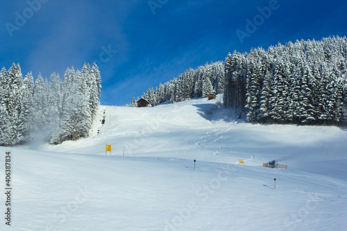 The 'Kleinberg' ski slope in wintertime with active snow cannon and fair weather in Filzmoos (Salzburg county, Austria)