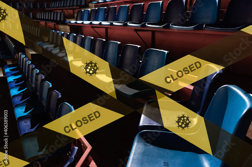 prohibitive tape on the background of a  empty plastic seats in a sports stadium arena in the dark. the stadium is closed for quarantine.