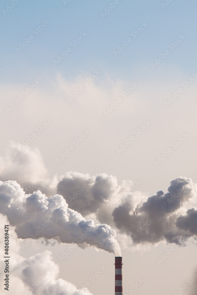 Copy space on vertical banner with heavy smoke from industrial chimneys causing air pollution on the blue sky background