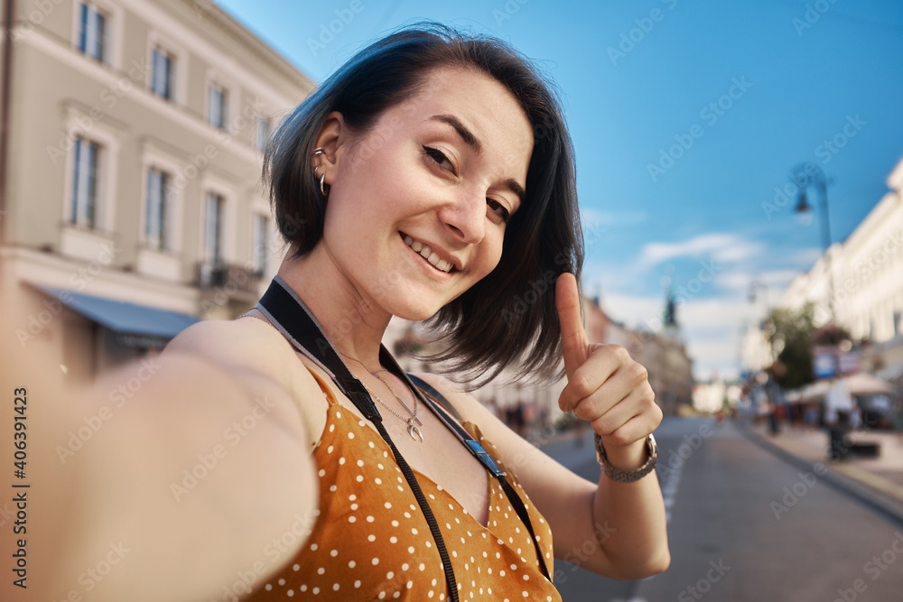 Female tourist taking selfie on the street, summer Eurotrip