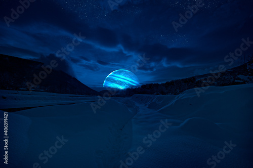 Mountain Road through the snowy forest on a full moon night. Scenic night winter landscape of dark blue sky with moon and stars