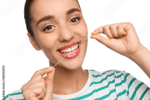 Young woman flossing her teeth on white background. Cosmetic dentistry
