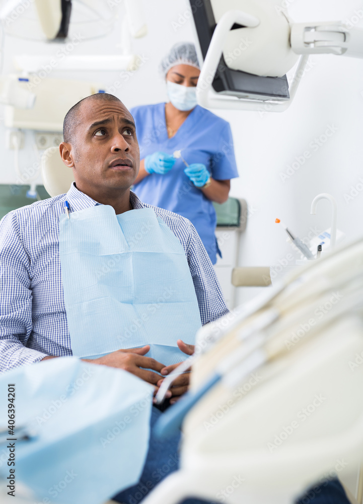 Fototapeta premium Patient is afraid to have his teeth treated at the dentist