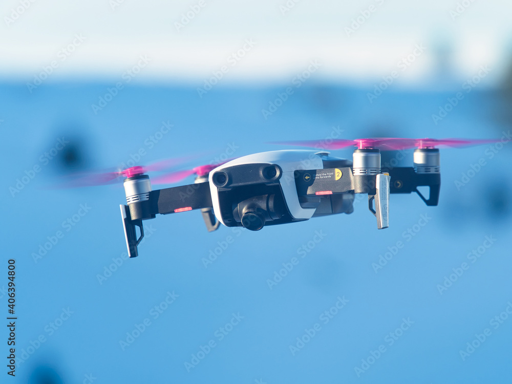 Fototapeta premium A drone with camera during the flight while filming and behind the blue sky