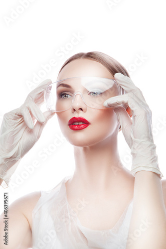 Fashion model woman portrait of wearing medical beautician uniform, doctor equipment, rubber gloves. Bright make-up, perfect skin