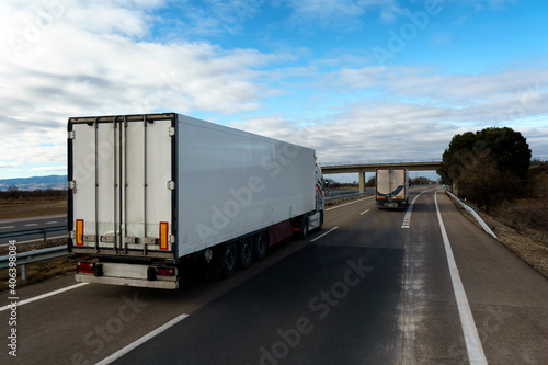 Camión frigorífico con temperatura controlada que transporta mercancías por carretera adelantando en la autovía.