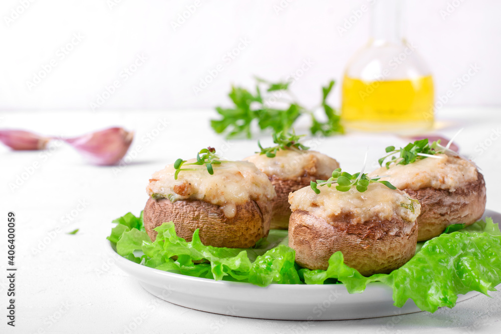 Stuffed champignons with cheese and garlic and roasted in the oven. Hot appetizer served on the white table Stuffed champignons with cheese and garlic and roasted in the oven. Hot appetizer served on the white table