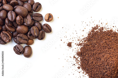 A pile of whole roasted coffee beans and another pile of grounded coffee on an isolated white background, from a high angle view covering the corners of the frame. 