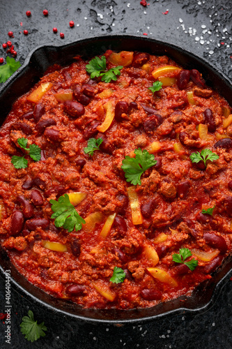 Vegetarian vegan mince chili con carne served in cast iron skillet pan