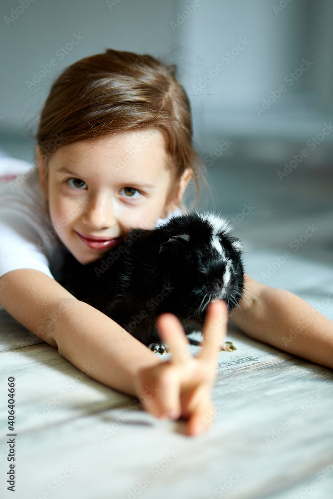Portrait of happy smiling little girl hugging black guinea pig. Portrait of happy smiling little girl hugging black guinea pig.