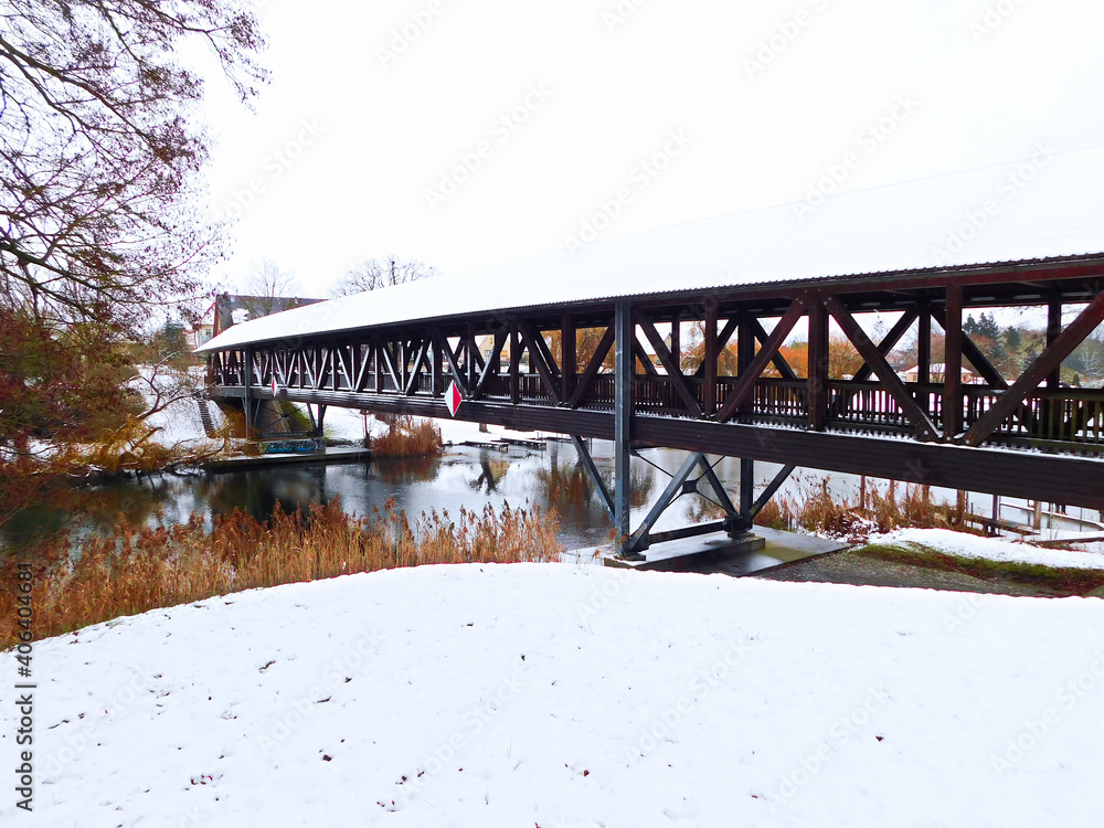 Die überdachte Pionierbrücke über den Fluss im Winter Die überdachte Pionierbrücke über den Fluss im Winter