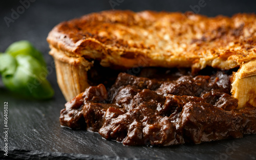 Tableau sur toile British beef steak pie with onion, wine gravy on rustic stone board
