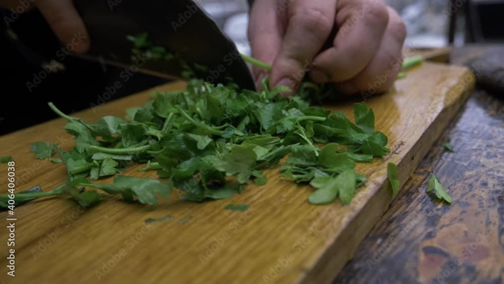Hands Cutting Fresh Parsley In A Wooden Chopping Board. - Close Up Hands Cutting Fresh Parsley In A Wooden Chopping Board. - Close Up