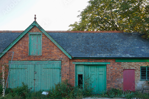 Rye, England - An old, run-down barn house with closed green wooden doors.  Image gives impression of abandonment and poverty, and has copy space.