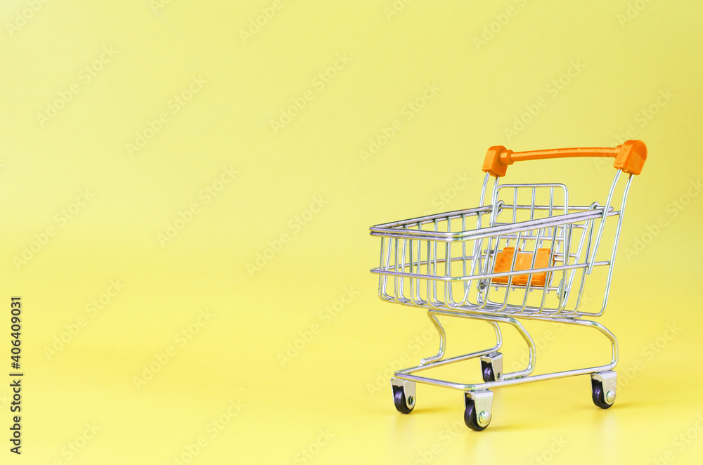 Orange empty metal basket on yellow background close-up trading concept Orange empty metal basket on yellow background close-up trading concept