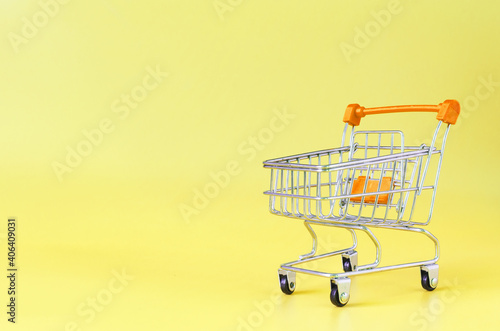 Orange empty metal basket on yellow background close-up trading concept