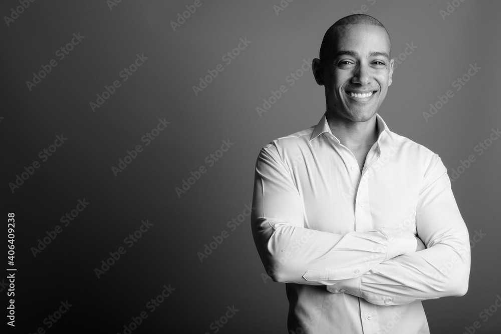 Obraz premium Happy handsome bald businessman against gray background