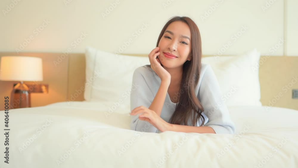 Close-up of an attractive young woman with flawless skin daydreaming while lying on her hotel suite bed. Close-up of an attractive young woman with flawless skin daydreaming while lying on her hotel suite bed.