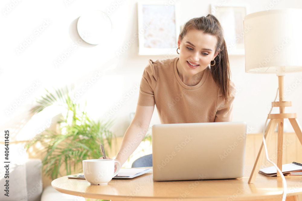 Young business woman standing in her home office reading notes.