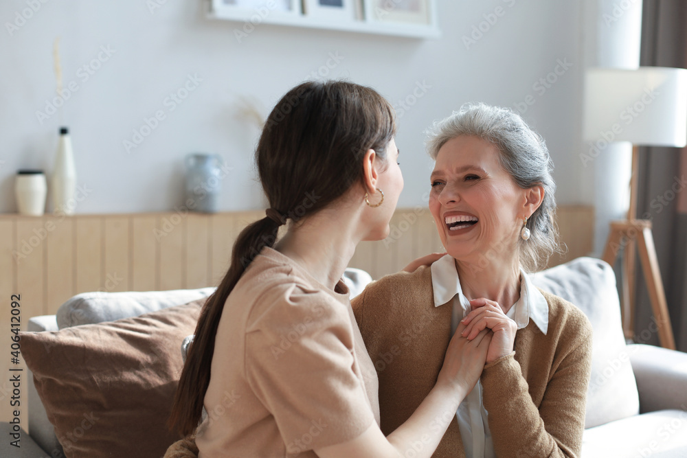 Portrait of old mother and mature daughter hugging at home. Happy senior mom and adult daughter embracing with love on sofa. Portrait of old mother and mature daughter hugging at home. Happy senior mom and adult daughter embracing with love on sofa.