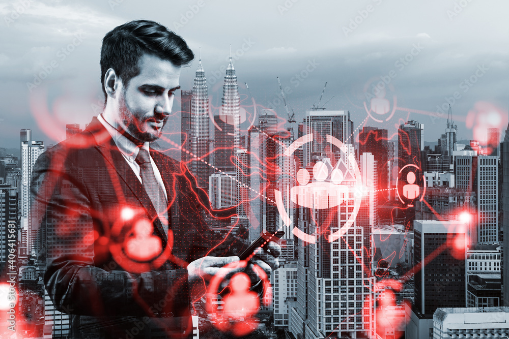 Obraz premium Handsome Caucasian HR director at international company is looking for highly qualified specialists to recruit by using smartphone. Social media hologram icons over Kuala Lumpur.