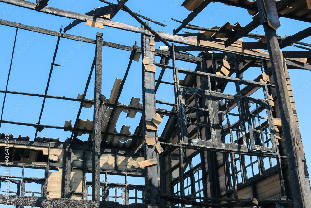 Burnt out house with charred roof trusses and burnt Burnt out house with charred roof trusses and burnt