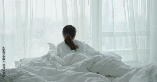 Woman lay down on bed and look outside the window