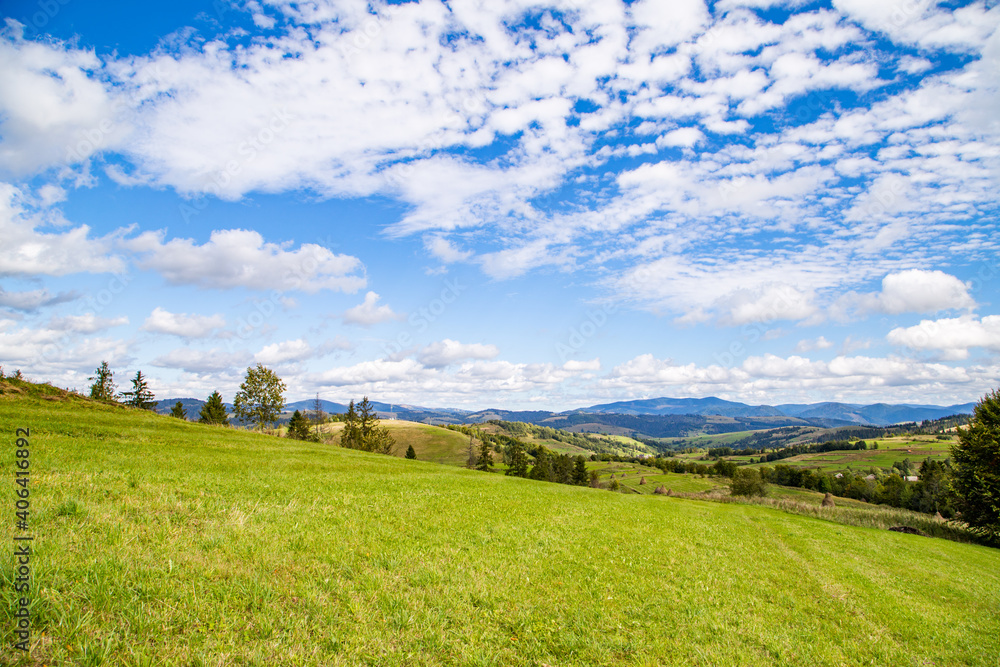 green glade overlooking the mountains and beautiful sky. Mountain range background.