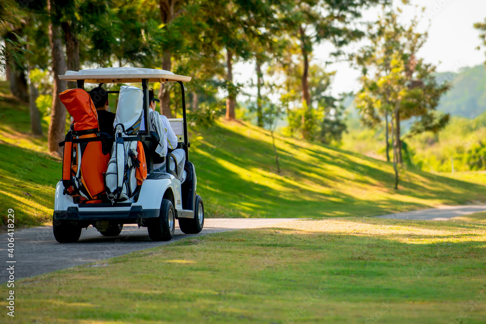 Golfer driving golf car on road in golf course